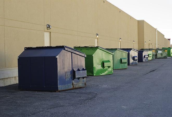 tilted front-load dumpsters being emptied by waste management workers in Capron IL